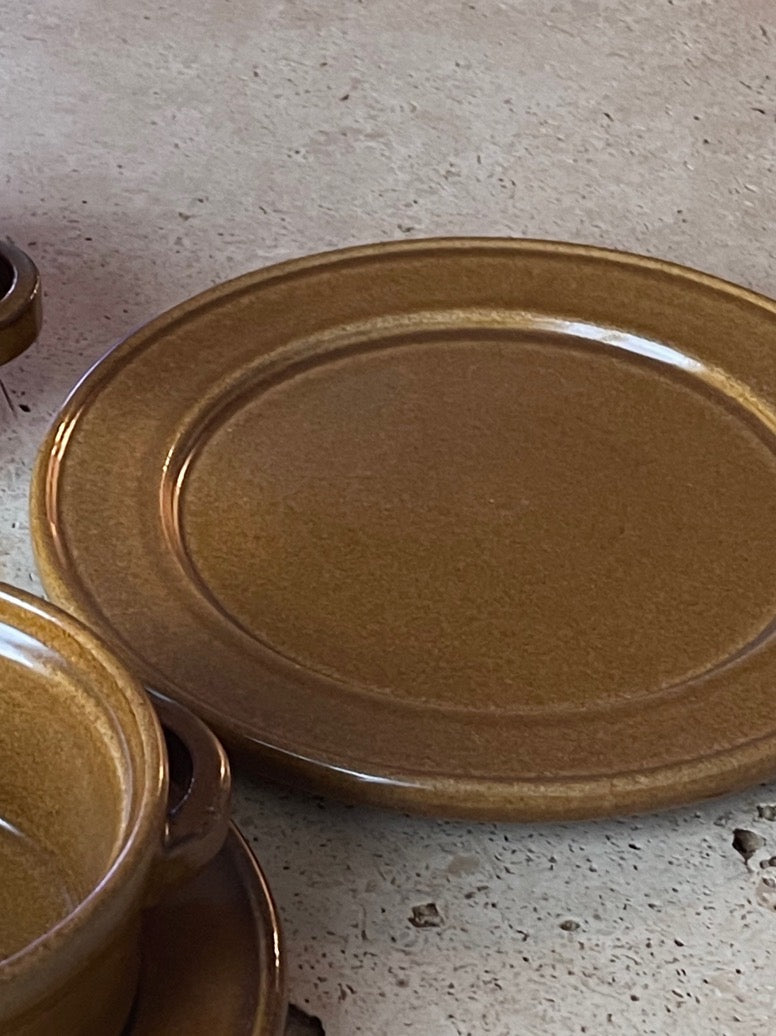 this is a brownish khaki plate, part of the dinnerware set. it's an artisanal kitchenware.